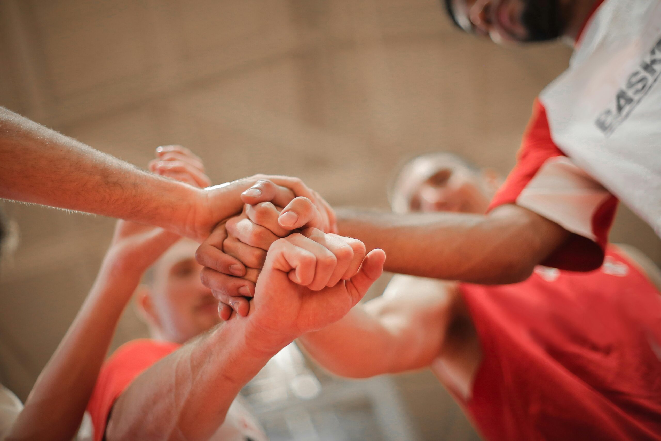 Wirral basketball team huddling with hands in — community and teamwork